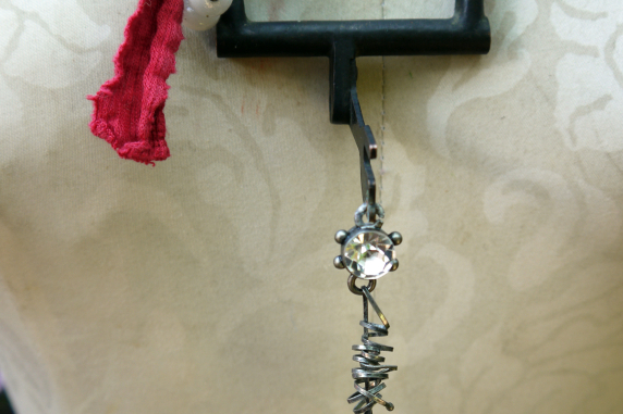 Recycled sewing machine part with hanging charm necklace